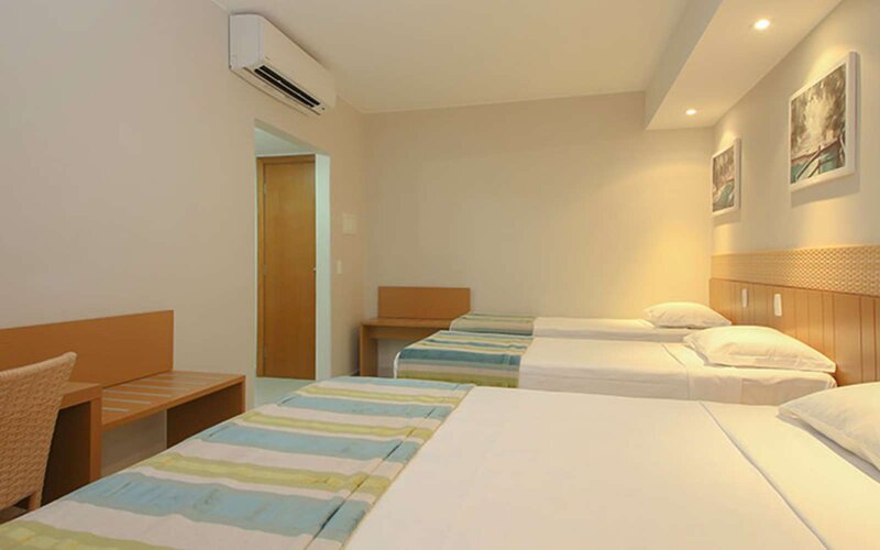 Imagem de quarto com tês camas: casal e filhos